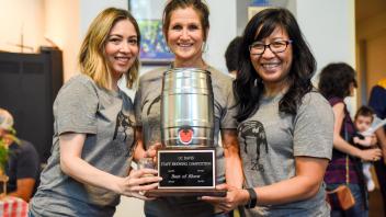 Three women holding Best of Show Trophy